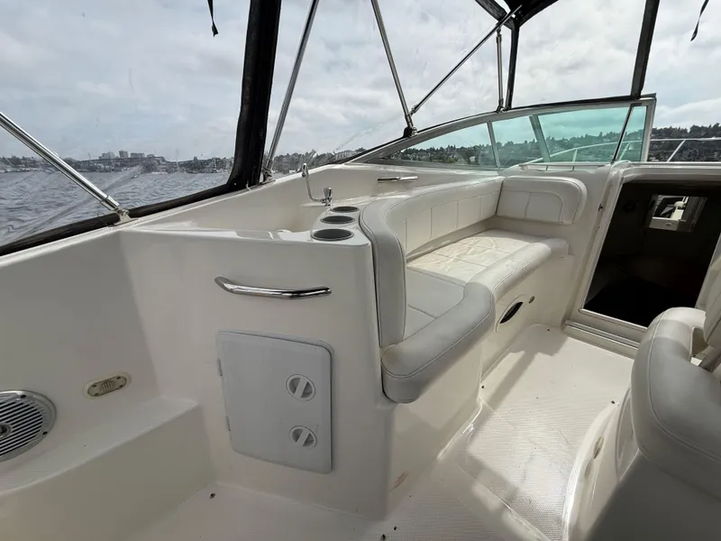 Slide: The Image of 2010 Bayliner 255 SB boat interior with white seating and open cabin view. - 9
