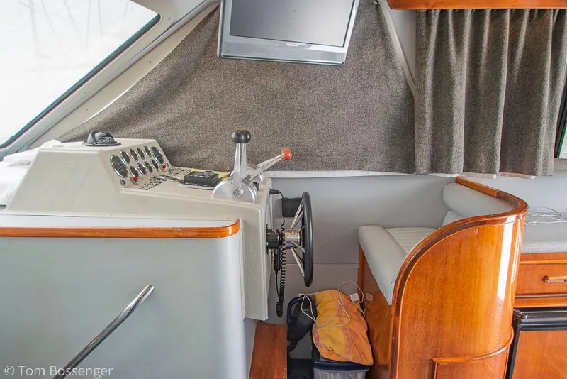 Slide: The Image of Interior of 1996 Mediterranean 38 Convertible boat with helm, steering wheel, and seating area. - 12