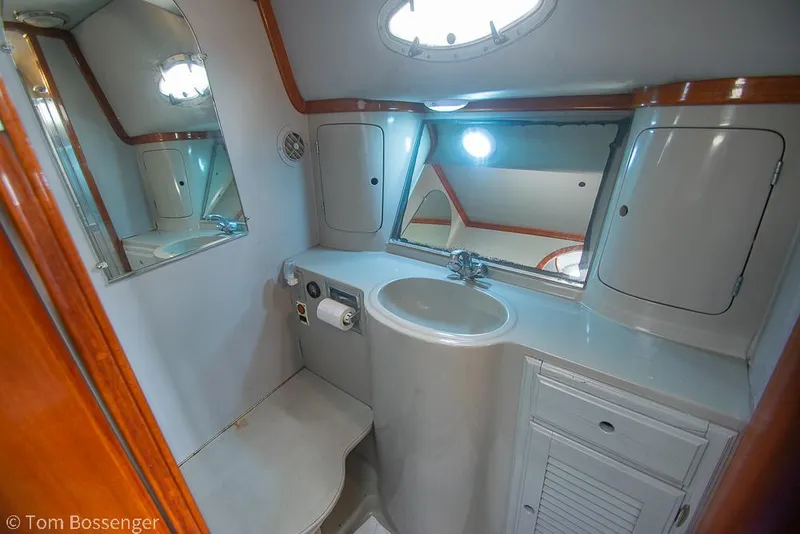 Slide: The Image of 1996 Mediterranean 38 Convertible yacht bathroom with sink, mirror, and storage cabinets. - 18