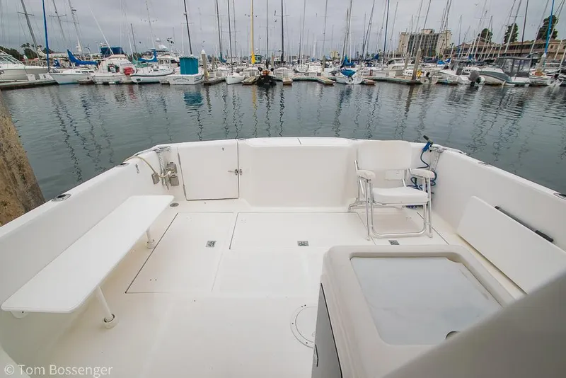 Slide: The Image of 1996 Mediterranean 38 Convertible yacht deck with marina view, featuring seating and storage. - 25