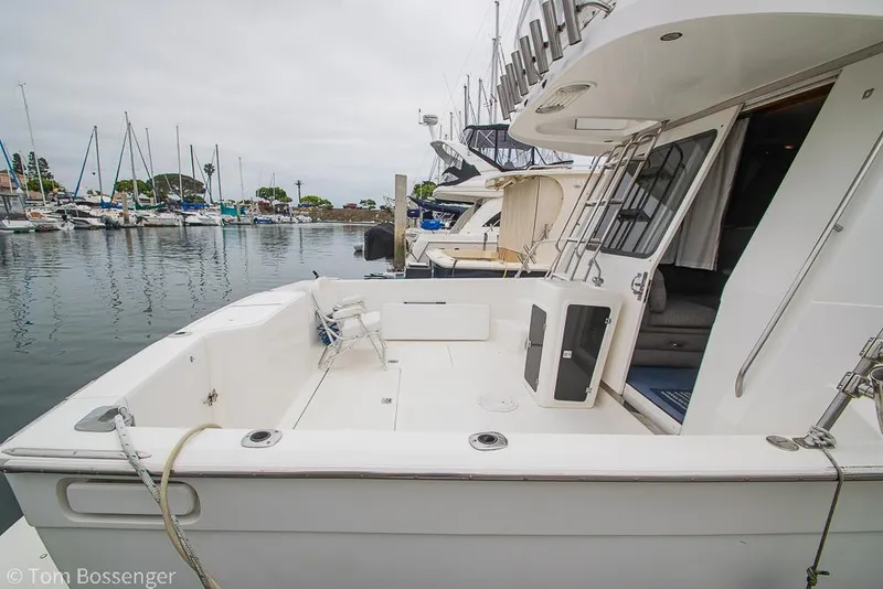 Slide: The Image of 1996 Mediterranean 38 Convertible yacht docked in a marina, showcasing spacious deck and sleek design. - 4