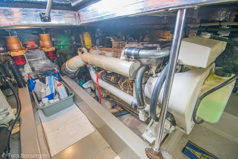 Slide: The Image of Engine room of a 1996 Mediterranean 38 Convertible boat, showcasing mechanical components and storage. - 43