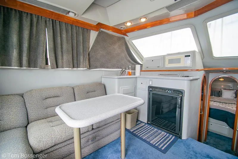 Slide: The Image of Interior of 1996 Mediterranean 38 Convertible yacht with sofa, table, kitchenette, and cozy cabin. - 7