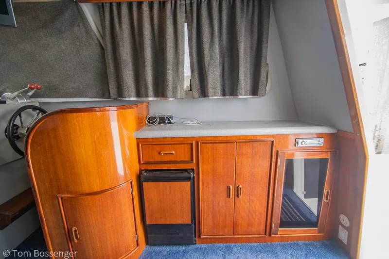 Slide: The Image of Interior of 1996 Mediterranean 38 Convertible yacht with wooden cabinetry and compact appliances. - 9