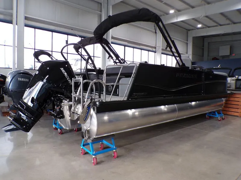 Slide: The Image of 2025 Premier 230 Sunsation RL pontoon boat in showroom, featuring sleek black design and powerful outboard motor. - 28