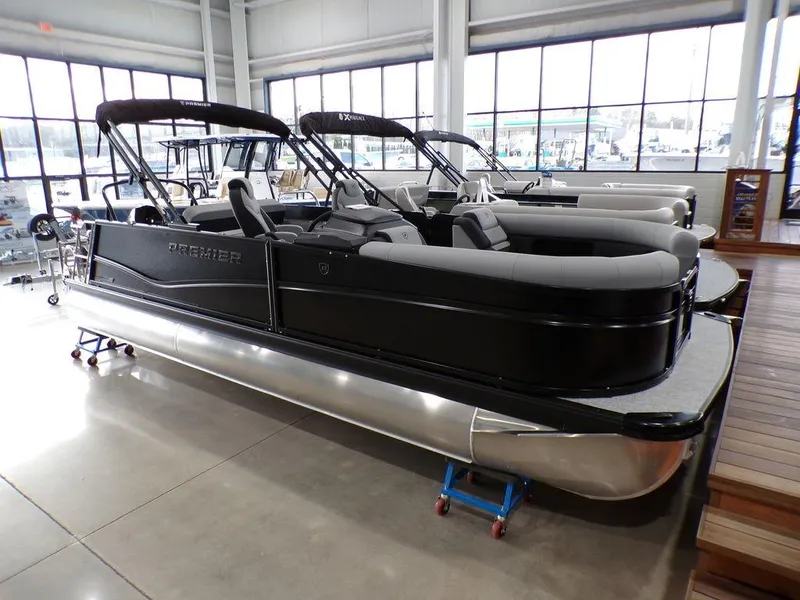 Slide: The Image of 2025 Premier 230 Sunsation RL pontoon boat in showroom, featuring sleek black design. - 30