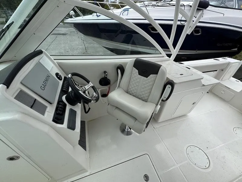 Slide: The Image of 2023 Sailfish 245 DC boat interior with Garmin navigation system and comfortable seating. - 11