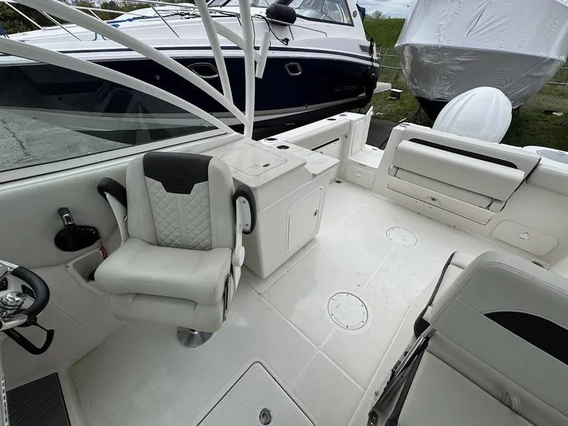 Slide: The Image of 2023 Sailfish 245 DC boat interior with white seating and storage compartments. - 2