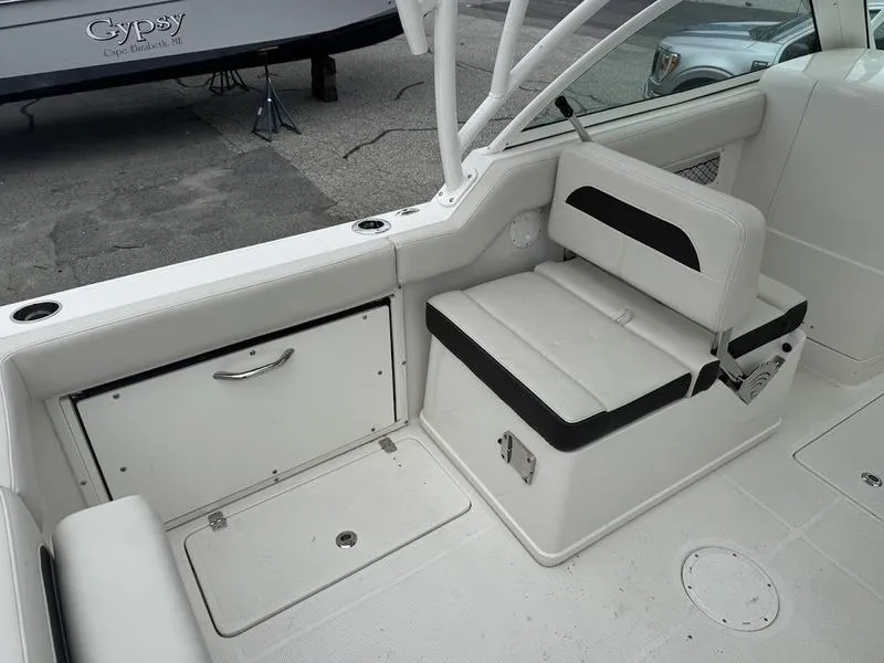 Slide: The Image of 2023 Sailfish 245 DC boat interior with white seating and storage compartments. - 8