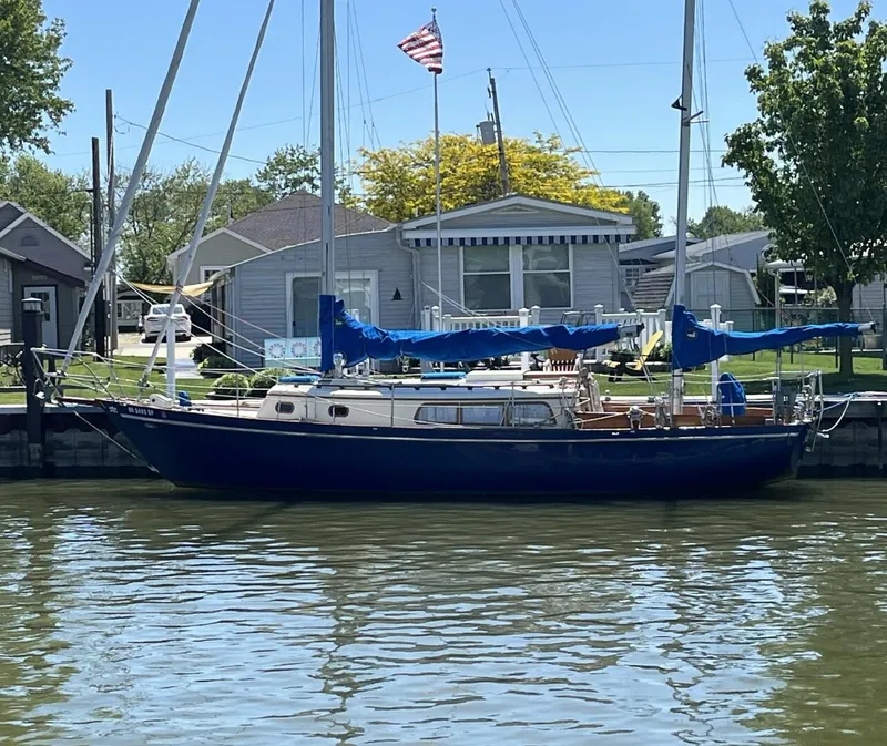 The Image of 1978 Cheoy Lee Offshore 33 sailboat docked by waterfront homes. - 1