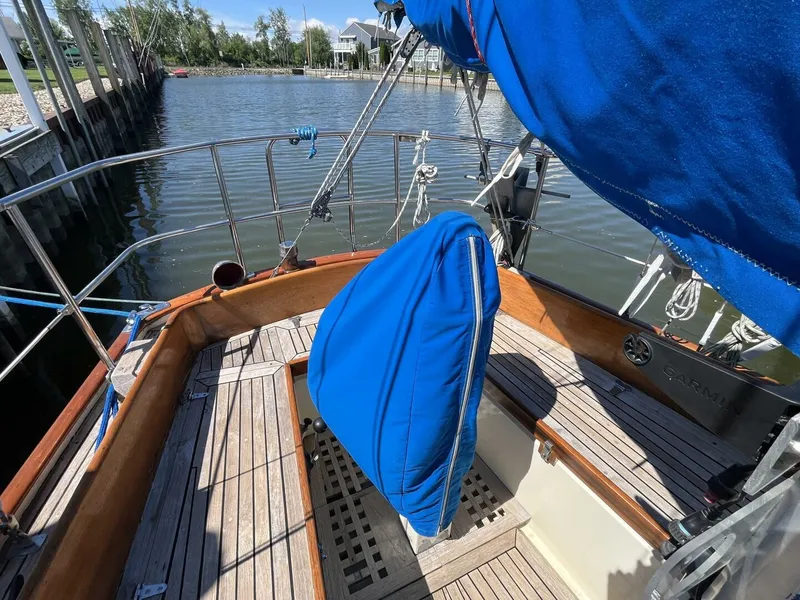 Slide: The Image of 1978 Cheoy Lee Offshore 33 sailboat deck with blue cover, docked by calm waters. - 13