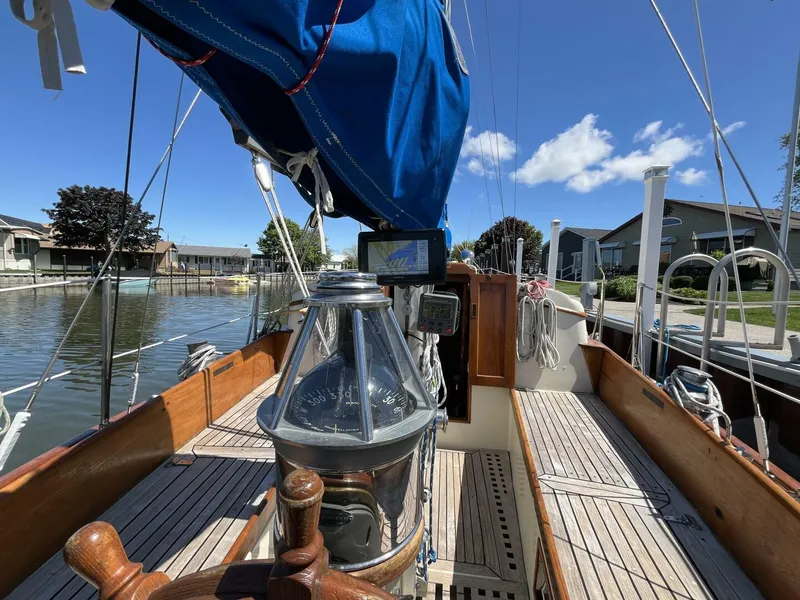 Slide: The Image of 1978 Cheoy Lee Offshore 33 sailboat with blue sail cover, docked in a serene marina. - 15