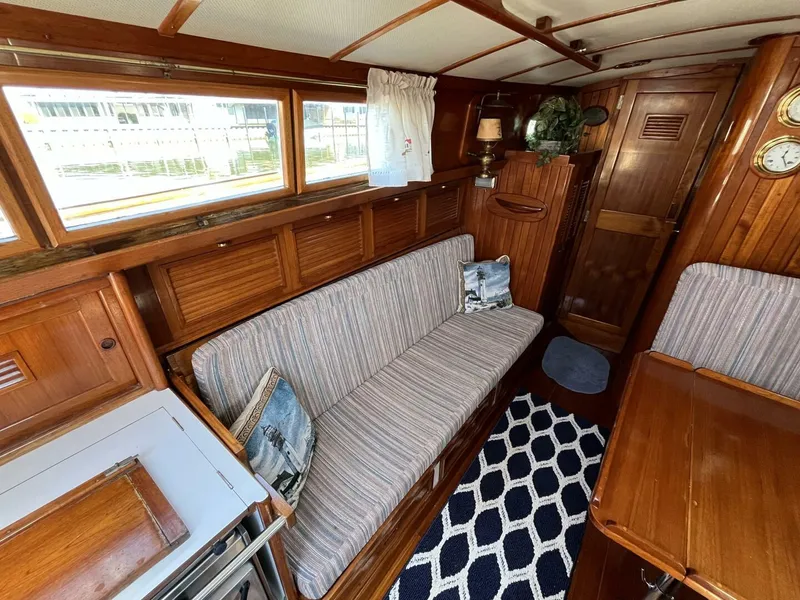 Slide: The Image of 1978 Cheoy Lee Offshore 33 interior with wooden finish, striped sofa, and nautical decor. - 20