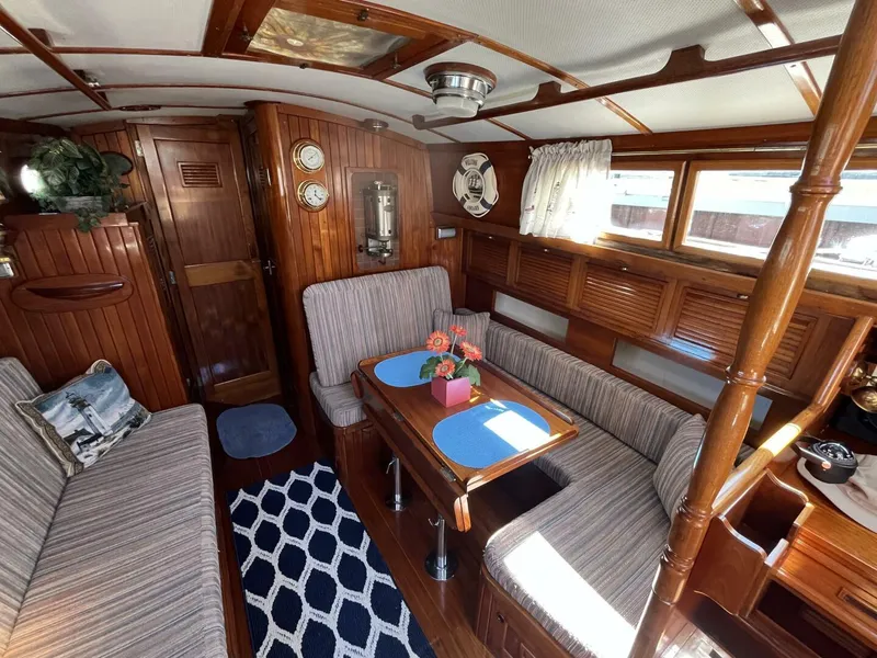 Slide: The Image of 1978 Cheoy Lee Offshore 33 yacht interior with wood paneling, cozy seating, and nautical decor. - 21