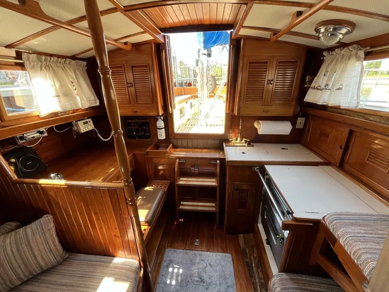 Slide: The Image of 1978 Cheoy Lee Offshore 33 yacht interior with wooden cabinetry and compact kitchen area. - 27