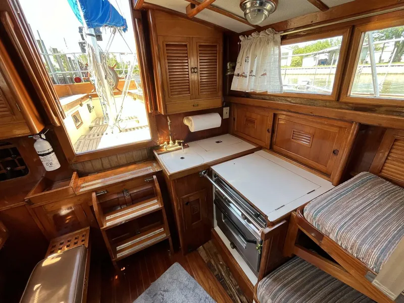 Slide: The Image of 1978 Cheoy Lee Offshore 33 yacht interior with wooden cabinetry and compact kitchen area. - 29
