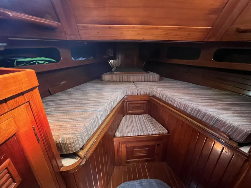 Slide: The Image of 1978 Cheoy Lee Offshore 33 cabin interior with wooden finish and striped cushions. - 32