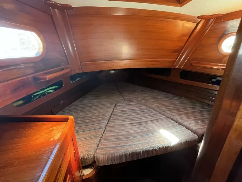 Slide: The Image of 1978 Cheoy Lee Offshore 33 cabin interior with wooden finish and cozy sleeping area. - 33