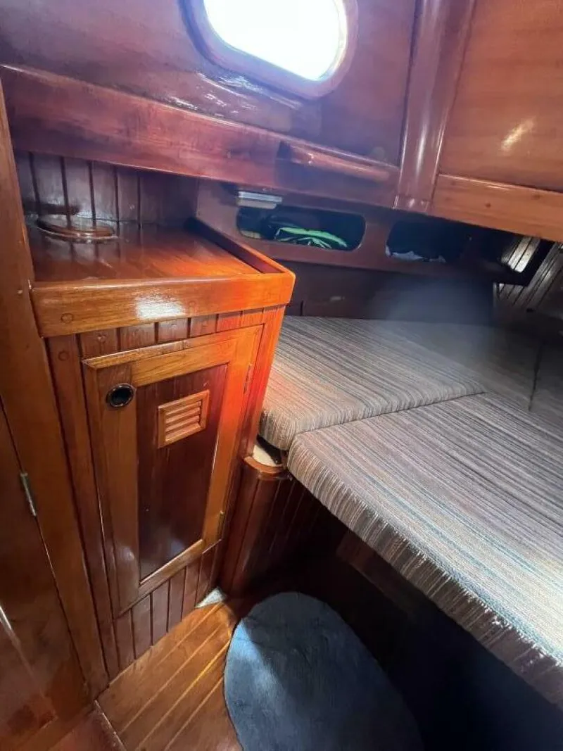 Slide: The Image of 1978 Cheoy Lee Offshore 33 cabin interior with wooden cabinetry and striped upholstery. - 34
