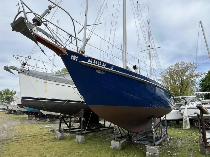 Slide: The Image of 1978 Cheoy Lee Offshore 33 sailboat on stands, blue hull, outdoor storage. - 4