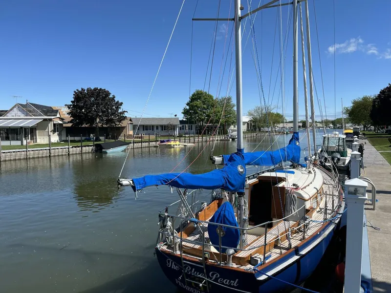 Slide: The Image of 1978 Cheoy Lee Offshore 33 sailboat docked on a sunny day, with blue covers. - 8
