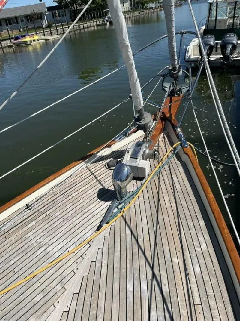 Slide: The Image of 1978 Cheoy Lee Offshore 33 sailboat deck with wooden finish, docked by calm waters. - 9
