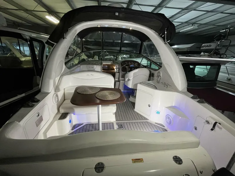 Slide: The Image of 2007 Sea Ray 280 Sundancer interior with seating and table, under a covered dock. - 17