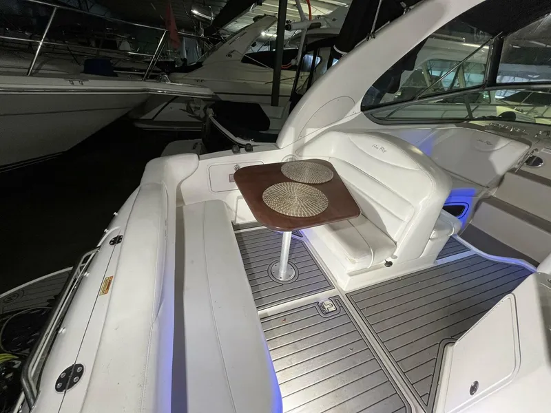 Slide: The Image of 2007 Sea Ray 280 Sundancer boat interior with seating and table in a marina. - 18