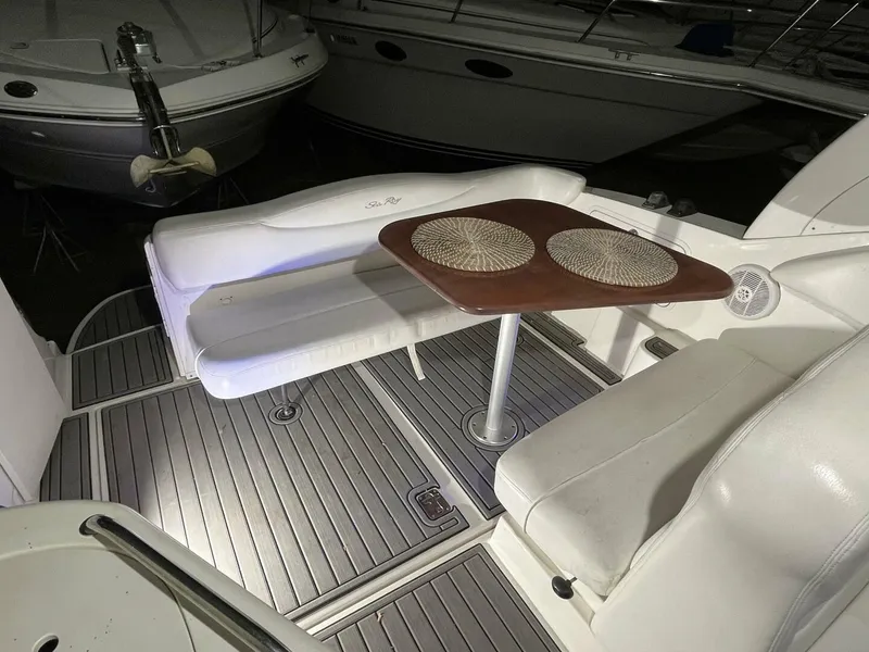 Slide: The Image of 2007 Sea Ray 280 Sundancer interior with seating and table, featuring elegant wood and white upholstery. - 19