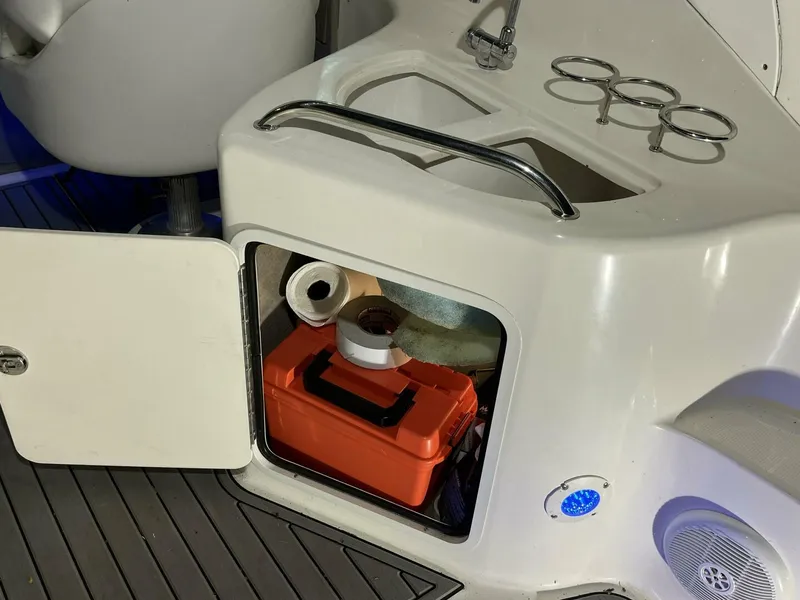 Slide: The Image of Storage compartment on a 2007 Sea Ray 280 Sundancer boat with orange toolbox and supplies. - 24