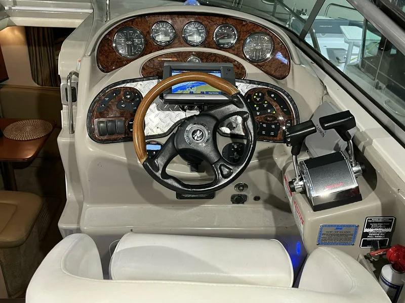 Slide: The Image of 2007 Sea Ray 280 Sundancer helm with wood-accented dashboard and modern controls. - 30