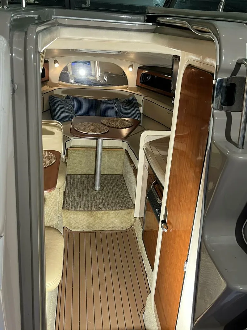 Slide: The Image of 2007 Sea Ray 280 Sundancer cabin interior with seating, table, and wood accents. - 43
