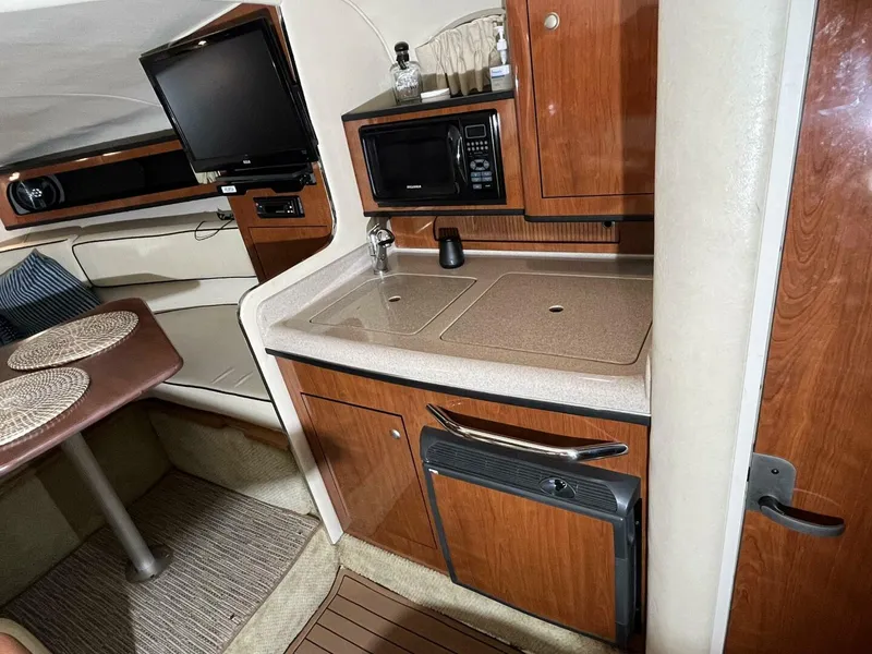 Slide: The Image of 2007 Sea Ray 280 Sundancer interior with kitchenette, TV, and dining area. - 45