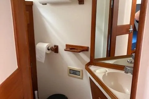 Slide: The Image of 1978 Grand Banks 36 Classic yacht bathroom with sink, mirror, and wooden accents. - 15