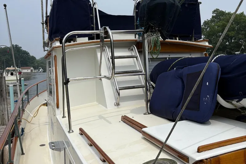 Slide: The Image of 1978 Grand Banks 36 Classic yacht deck with ladder and blue cushions. - 25