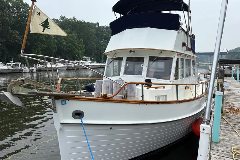 Slide: The Image of 1978 Grand Banks 36 Classic boat docked at a marina, featuring a distinctive flag. - 26