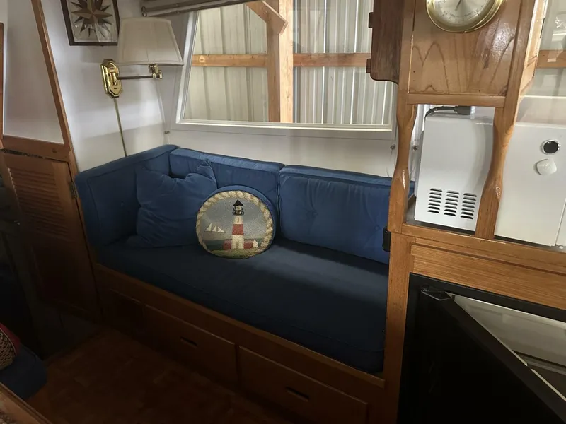 Slide: The Image of 1978 Grand Banks 36 Classic interior with blue sofa and lighthouse-themed pillow. - 5