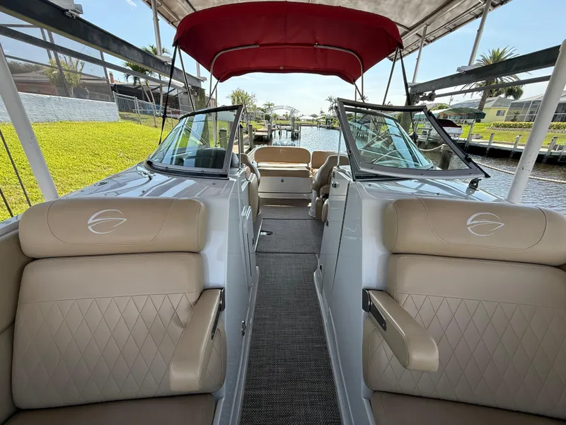 Slide: The Image of 2019 Crownline Eclipse E255 XS boat interior with tan seating and red canopy. - 10