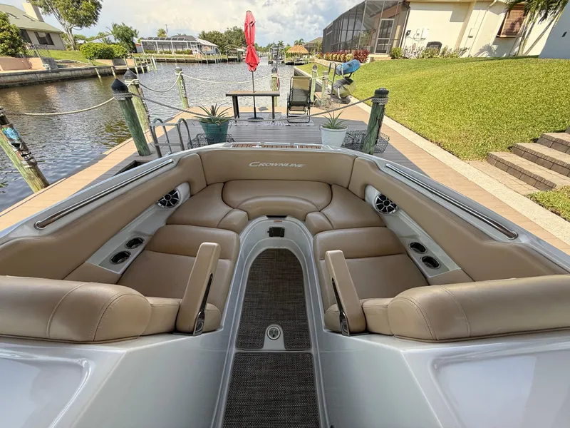 Slide: The Image of 2019 Crownline Eclipse E255 XS boat with spacious seating, docked by a scenic canal. - 11
