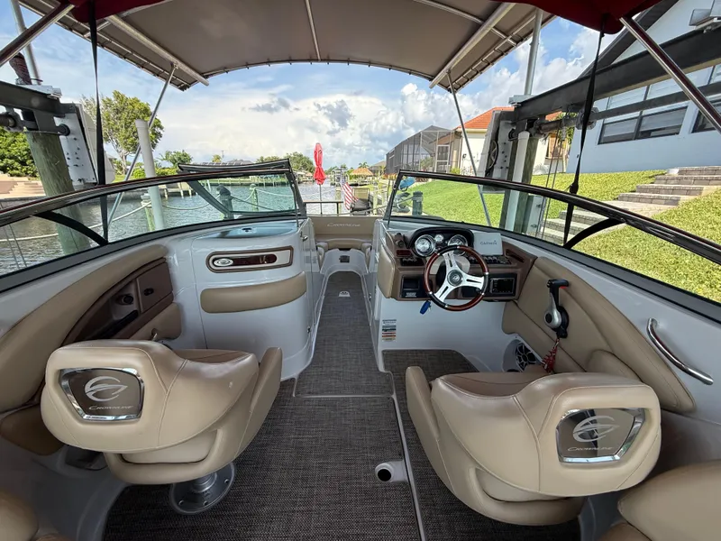 Slide: The Image of 2019 Crownline Eclipse E255 XS boat interior with beige seating and modern dashboard. - 12