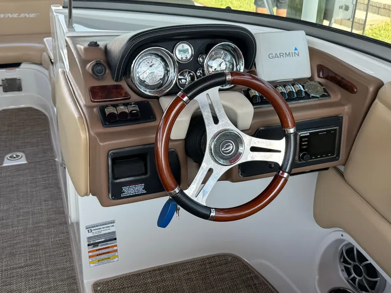 Slide: The Image of 2019 Crownline Eclipse E255 XS boat dashboard with Garmin navigation and wood-accented steering wheel. - 15