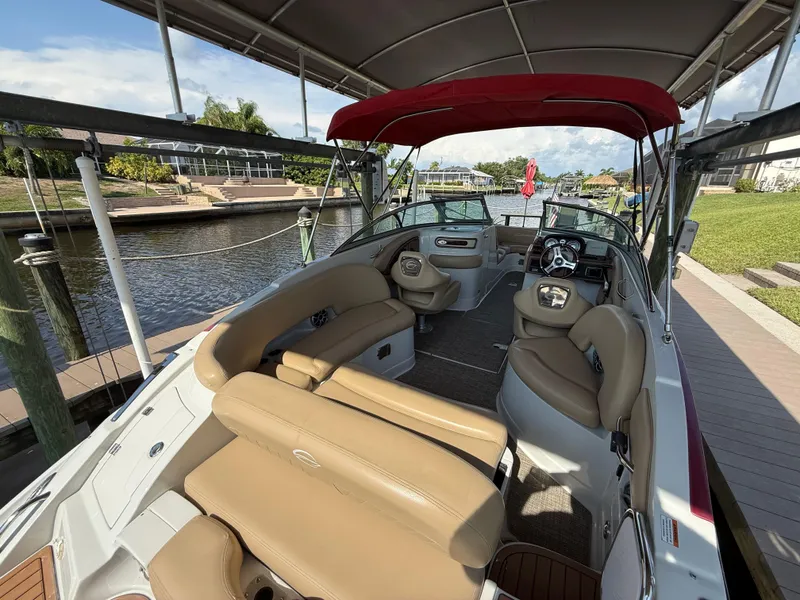 Slide: The Image of 2019 Crownline Eclipse E255 XS boat interior with tan seating, docked by a canal. - 5