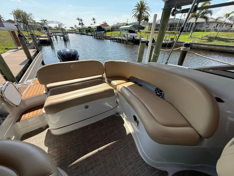 Slide: The Image of 2019 Crownline Eclipse E255 XS boat with tan seating, docked by a scenic canal. - 7