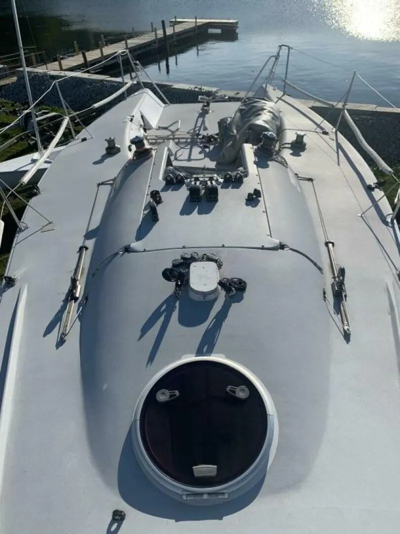 Slide: The Image of Sailboat deck of a 1996 Farr 30, docked by a serene waterfront. - 11