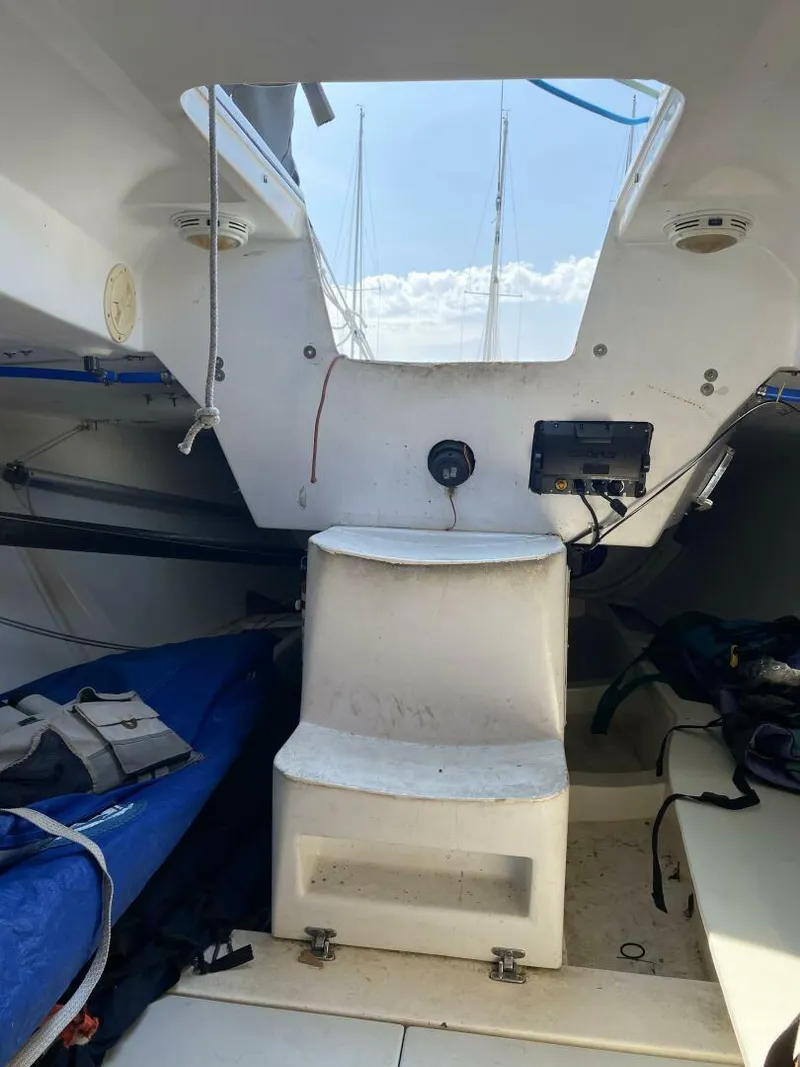 Slide: The Image of Interior view of a 1996 Farr 30 sailboat, featuring seating and storage areas. - 13