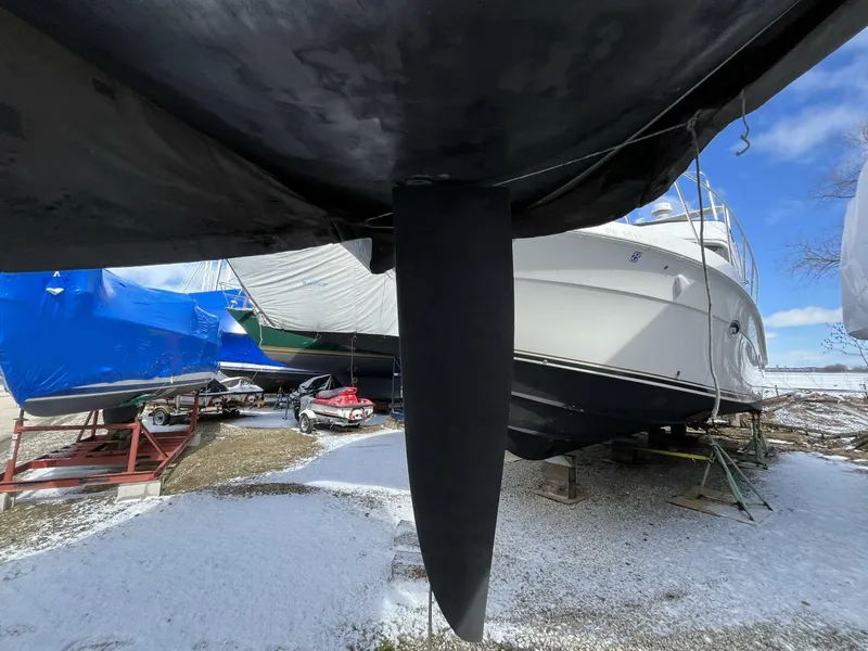 Slide: The Image of 1996 Farr 30 sailboat keel, stored outdoors, surrounded by other covered boats. - 6