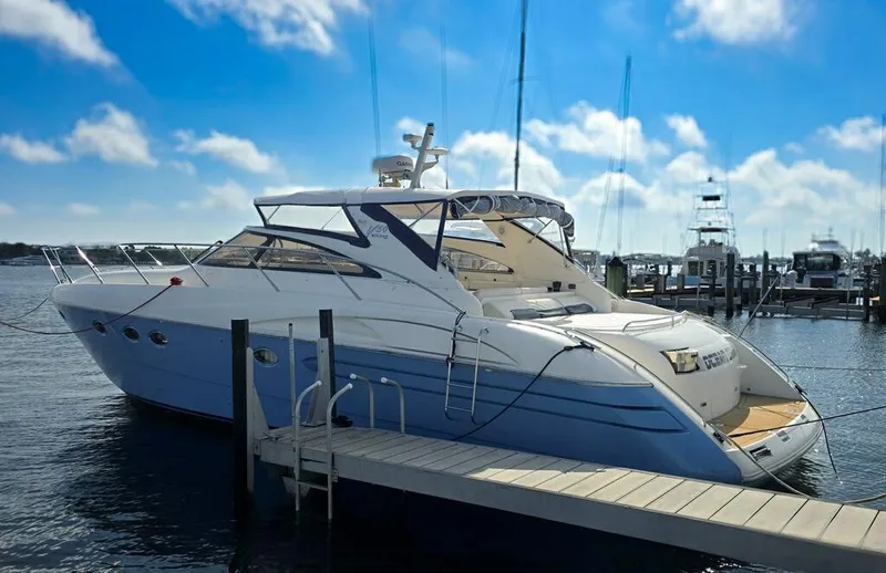 The Image of 2003 Viking Princess V50 Express yacht docked at marina under blue sky. - 0