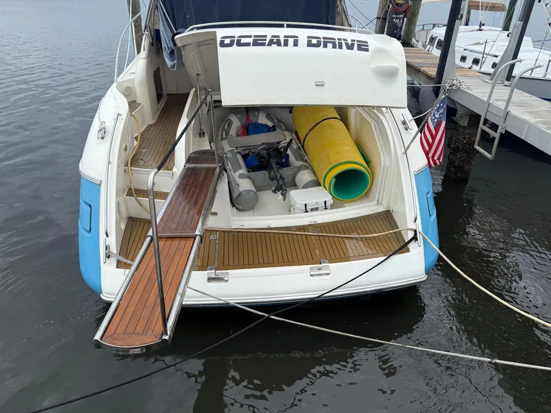 Slide: The Image of 2003 Viking Princess V50 Express yacht docked, featuring open stern with equipment and American flag. - 18