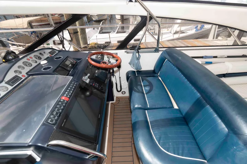Slide: The Image of 2003 Viking Princess V50 Express yacht cockpit with blue seating and modern dashboard controls. - 7