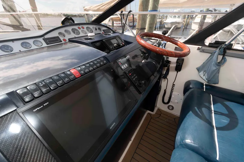 Slide: The Image of 2003 Viking Princess V50 Express yacht helm with wooden steering wheel and navigation controls. - 8